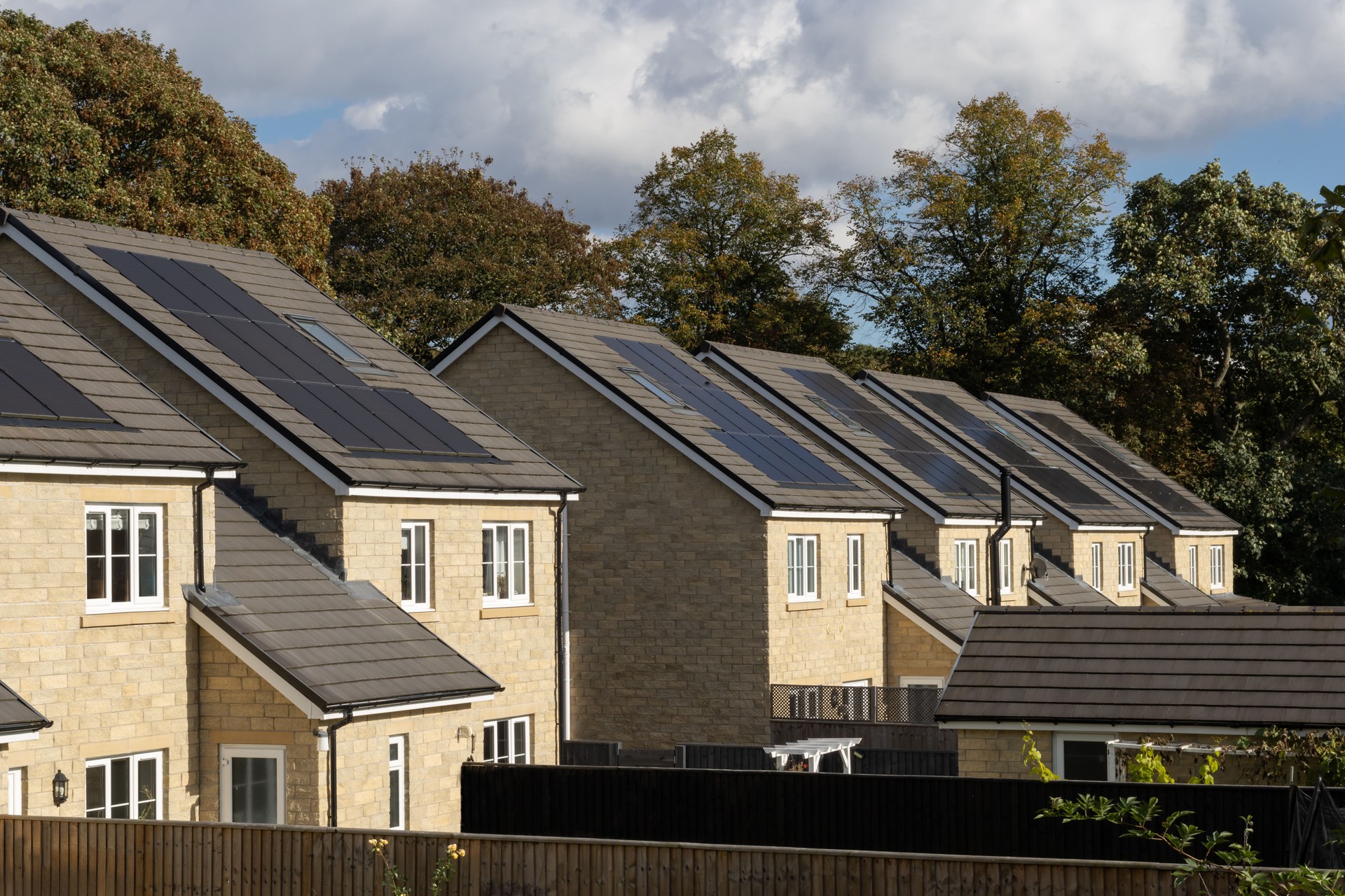Street of six modern suburban UK family houses with solar panels